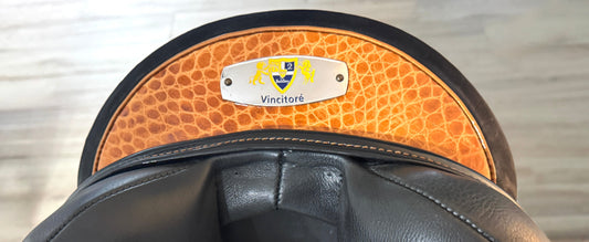 Close-up of a black leather saddle with brown leather flap.